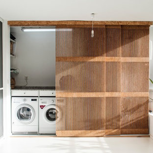 This is an example of a small contemporary single-wall laundry cupboard in Valencia with a side by side washer and dryer.
