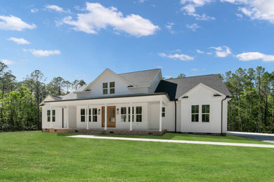 Example of a large cottage white two-story board and batten exterior home design in Raleigh with a shingle roof