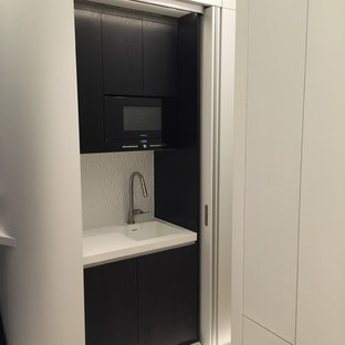 Réalisation d'une petite arrière-cuisine linéaire design avec un évier intégré, un placard à porte affleurante, des portes de placard en bois sombre, un plan de travail en surface solide, une crédence blanche, un électroménager de couleur et aucun îlot.