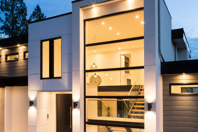Large trendy gray three-story metal exterior home photo in Vancouver with a green roof