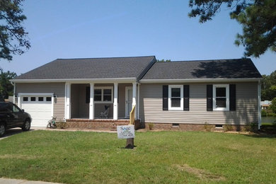 Elegant beige one-story vinyl exterior home photo in Other