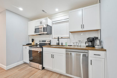 Kitchen - contemporary kitchen idea in Other with shaker cabinets and white backsplash