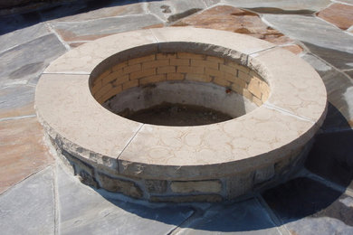 This is an example of a stone landscaping in Other with a fire pit.