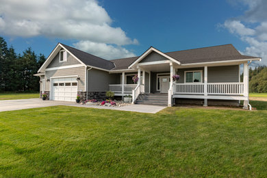 Example of an arts and crafts gray concrete fiberboard house exterior design in Seattle with a hip roof and a shingle roof