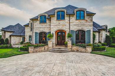 Huge traditional beige two-story stone gable roof idea in Little Rock