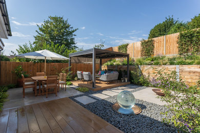 Imagen de jardín de tamaño medio en verano en patio trasero con pérgola