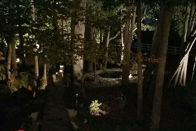 This is an example of a large rustic shade backyard stone landscaping in Raleigh for fall.
