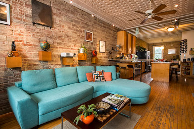 Small minimalist loft-style medium tone wood floor living room photo in Kansas City with yellow walls, no fireplace and no tv