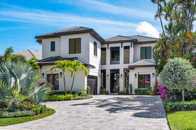 Transitional white two-story stucco exterior home photo in Miami with a tile roof and a gray roof