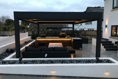 This is an example of a large contemporary back formal partial sun garden for summer in Other with a waterfall, natural stone paving and a wood fence.