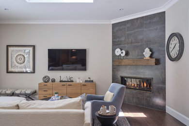 Inspiration for a mid-sized cottage enclosed medium tone wood floor and brown floor living room remodel in San Francisco with beige walls, a corner fireplace, a tile fireplace and a wall-mounted tv