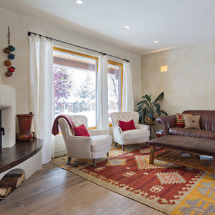 Diseño de salón cerrado, mediterráneo, de tamaño medio, con paredes beige, suelo de madera en tonos medios, chimenea de esquina y marco de chimenea de yeso