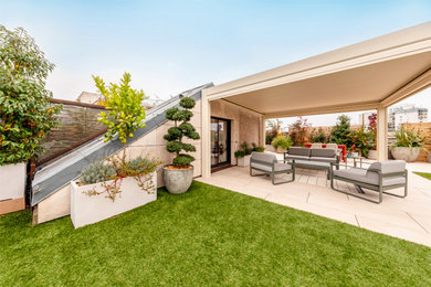 Réalisation d'une grande terrasse minimaliste avec une cuisine d'été, du carrelage et une pergola.