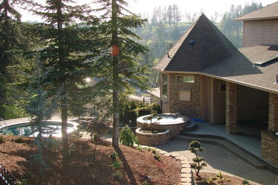 Example of a large tuscan backyard stamped concrete patio fountain design in Portland with no cover