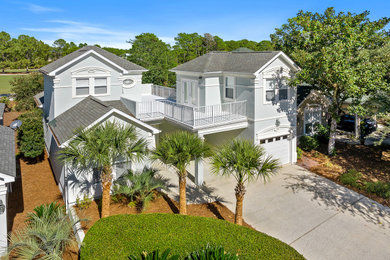 Example of a beach style two-story stucco exterior home design in Other