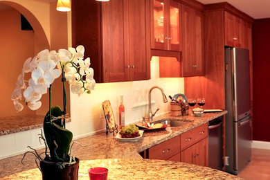Kitchen - light wood floor kitchen idea in DC Metro with a single-bowl sink, recessed-panel cabinets, medium tone wood cabinets, granite countertops, stainless steel appliances and a peninsula