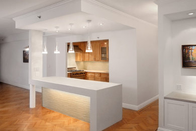 Mid-sized trendy u-shaped medium tone wood floor open concept kitchen photo in New York with an undermount sink, recessed-panel cabinets, medium tone wood cabinets, solid surface countertops, white backsplash, mosaic tile backsplash, stainless steel appliances and an island