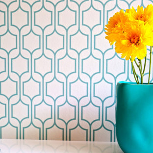 This is an example of a small modern study in San Francisco with white walls, medium hardwood flooring and a freestanding desk.