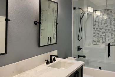 Bathroom - small transitional kids' gray tile and marble tile porcelain tile, white floor, double-sink and wainscoting bathroom idea in Portland with black cabinets, a one-piece toilet, gray walls, an undermount sink, quartz countertops, a hinged shower door, white countertops and a built-in vanity