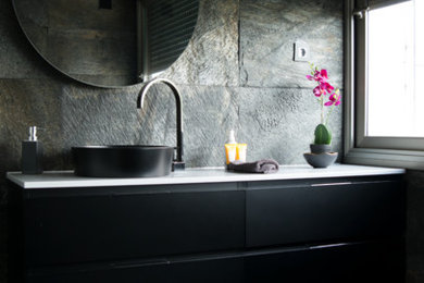 Imagen de cuarto de baño principal moderno grande con puertas de armario negras, ducha a ras de suelo, baldosas y/o azulejos negros, losas de piedra, encimera de cuarzo compacto, ducha abierta y encimeras blancas
