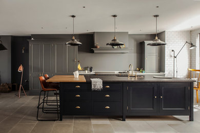 Design ideas for a transitional single-wall kitchen in London with recessed-panel cabinets, black cabinets and with island.