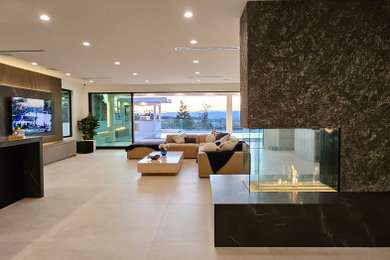 Inspiration for a mid-sized modern galley porcelain tile and white floor wet bar remodel in Los Angeles with a drop-in sink, marble countertops and black countertops