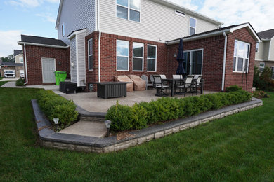 Ejemplo de patio moderno de tamaño medio sin cubierta en patio trasero con suelo de hormigón estampado