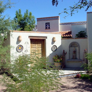 Idée de décoration pour une grande porte d'entrée sud-ouest américain avec un mur blanc, un sol en carreau de terre cuite, une porte double, une porte en bois brun et un sol multicolore.