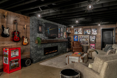 Example of a huge urban underground concrete floor, gray floor, exposed beam and wood wall basement game room design in Philadelphia with brown walls, a ribbon fireplace and a stacked stone fireplace