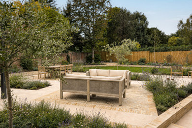 Large contemporary back patio in Kent with natural stone paving.