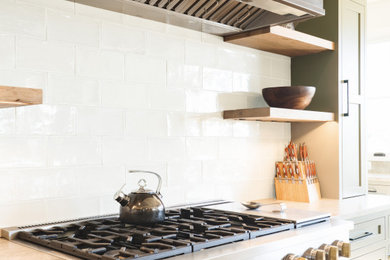 Inspiration for a large transitional l-shaped light wood floor and beige floor eat-in kitchen remodel in DC Metro with a farmhouse sink, green cabinets, quartzite countertops, beige backsplash, ceramic backsplash, stainless steel appliances, an island and multicolored countertops