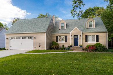 Example of a classic beige vinyl house exterior design in DC Metro with a shingle roof