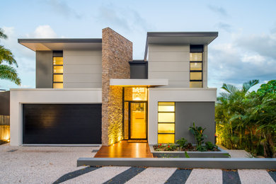 This is an example of a large contemporary three-storey grey house exterior in Sunshine Coast with stone veneer, a flat roof and a metal roof.