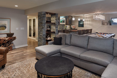 Design ideas for a mid-sized transitional look-out basement in Other with grey walls, vinyl floors, a ribbon fireplace, a stone fireplace surround and brown floor.