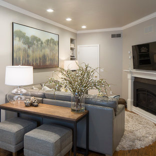 Inspiration for a small modern enclosed family room in Phoenix with grey walls, medium hardwood floors, a standard fireplace and a wall-mounted tv.