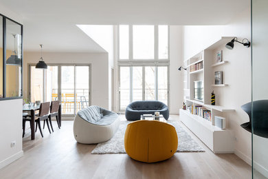 Design ideas for a mid-sized scandinavian formal open concept living room in Paris with white walls, light hardwood floors, no fireplace and a wall-mounted tv.