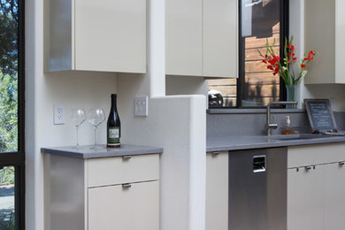 Eat-in kitchen - small modern galley ceramic tile eat-in kitchen idea in Other with an undermount sink, flat-panel cabinets, beige cabinets, quartz countertops, gray backsplash, stone slab backsplash, stainless steel appliances and no island