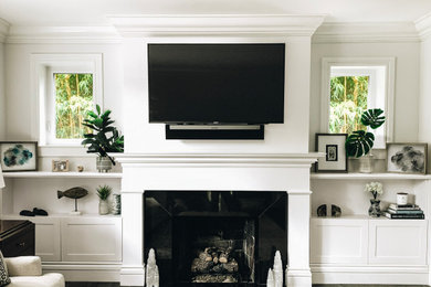 Inspiration for a transitional porcelain tile and gray floor family room remodel in Miami with white walls, a standard fireplace, a stone fireplace and a wall-mounted tv