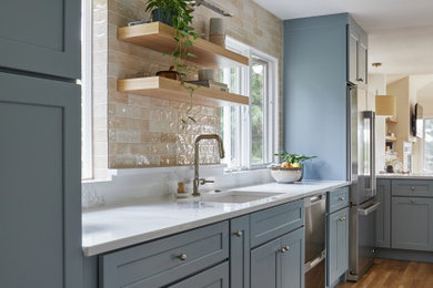 Large cottage chic eat-in kitchen photo in Portland with shaker cabinets, blue cabinets, quartzite countertops, beige backsplash, stainless steel appliances, no island and white countertops