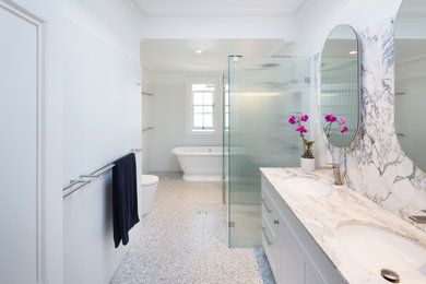 Design ideas for a bathroom in Sydney with a freestanding tub, a double shower, a one-piece toilet, white tile, ceramic tile, multi-coloured walls, terrazzo floors, grey floor, a hinged shower door, a niche and a double vanity.