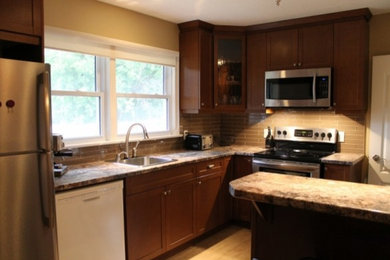 Kitchen - traditional light wood floor and beige floor kitchen idea in Toronto with a drop-in sink, shaker cabinets, dark wood cabinets, granite countertops, beige backsplash, glass tile backsplash, stainless steel appliances and a peninsula
