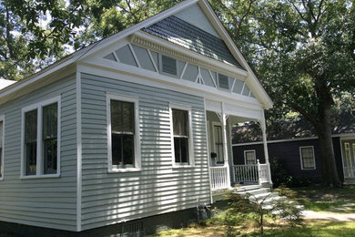 Example of a mid-sized classic gray one-story wood exterior home design in Miami with a clipped gable roof