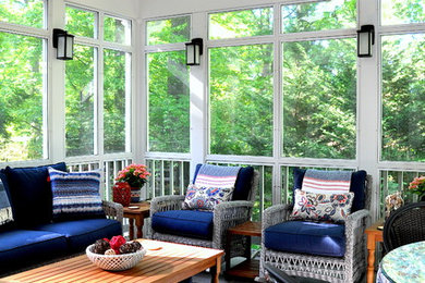 This is an example of a mid-sized traditional screened-in back porch design in DC Metro with decking and a roof extension.