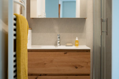 Cette image montre une petite salle de bain principale et grise et blanche design avec des portes de placard marrons, une douche à l'italienne, un carrelage gris, des carreaux de céramique, un mur gris, un sol en carrelage de céramique, un lavabo suspendu, un sol gris, une cabine de douche à porte coulissante, un plan de toilette blanc, meuble simple vasque et meuble-lavabo suspendu.
