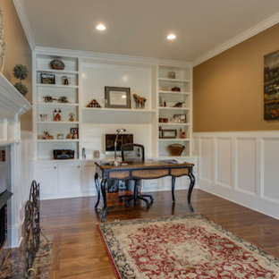 Photo of a modern study in Nashville with brown walls, dark hardwood flooring, a standard fireplace, a tiled fireplace surround, a freestanding desk and brown floors.