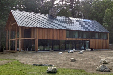 Modelo de fachada de casa marrón minimalista grande de dos plantas con revestimiento de madera, tejado a dos aguas y tejado de metal
