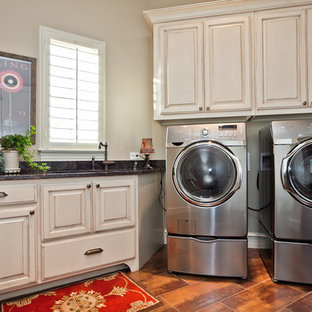 This is an example of a traditional separated utility room in Dallas with raised-panel cabinets, beige cabinets, beige walls, a side by side washer and dryer and orange floors.