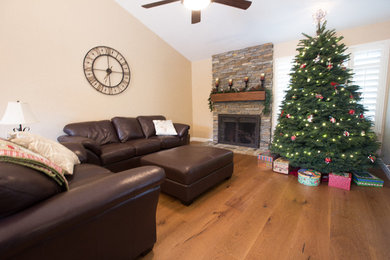 Example of a small classic medium tone wood floor family room design in Los Angeles with beige walls, a standard fireplace and a brick fireplace