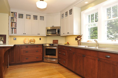 Elegant u-shaped light wood floor kitchen photo in Toronto with a double-bowl sink, shaker cabinets, dark wood cabinets, granite countertops, stainless steel appliances and no island