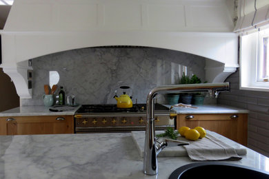 Example of a french country l-shaped marble floor and white floor eat-in kitchen design in Other with a drop-in sink, shaker cabinets, light wood cabinets, marble countertops, white backsplash, marble backsplash, stainless steel appliances, two islands and white countertops
